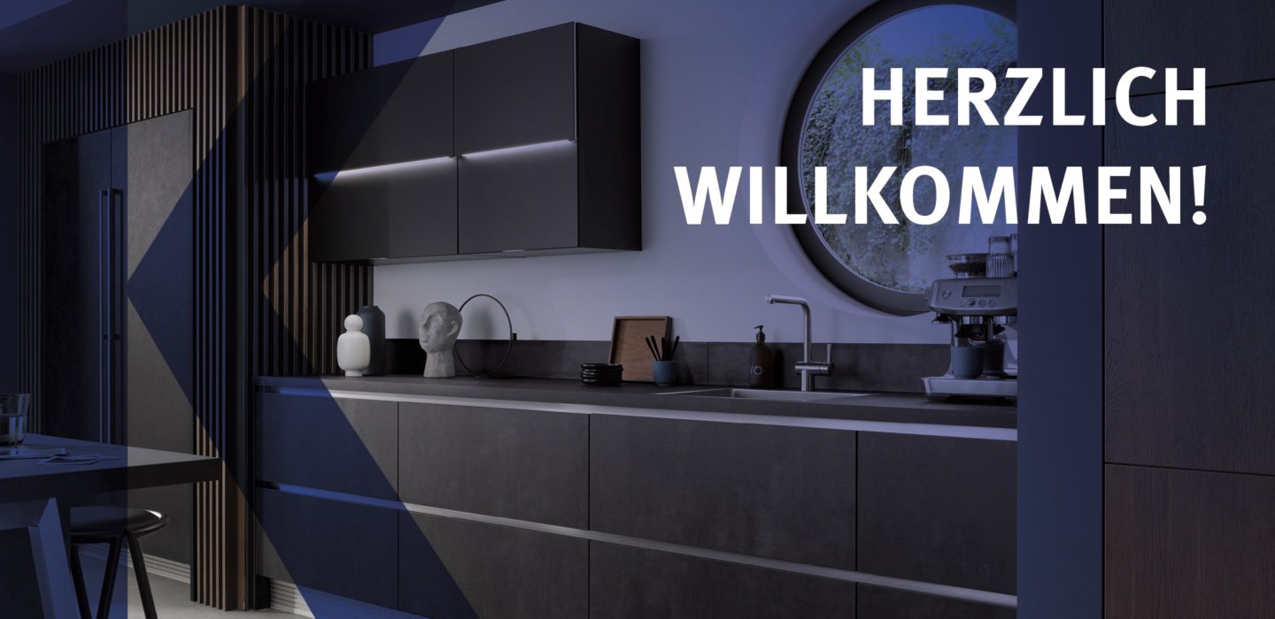 Bild von einer dunklen Küche mit Beleuchtung und der Schrift "Herzlich Willkommen!" darauf