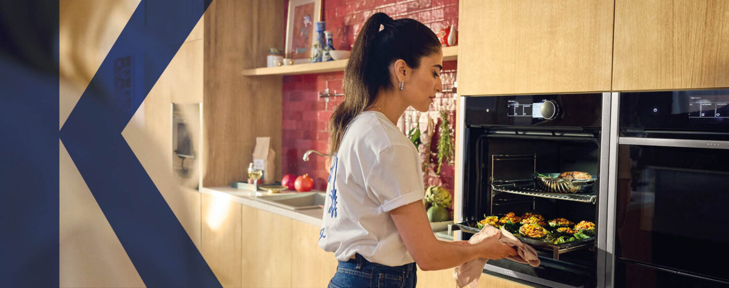 Frau nimmt ein Gericht aus einem hochwertigen Backofen von NEFF