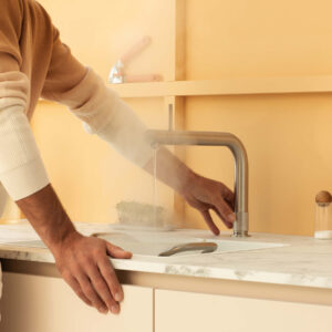 Mann betätigt Quooker Wasserhahn für kochend heißes Wasser