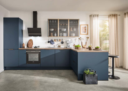 Klassische Häcker Küche in Blau mit Holzarbeitsplatte und modernen Einbaugeräten