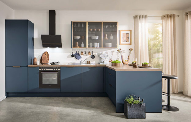 Stilvolle Häcker Designküche bei Küchenstudio Kandy Bücker mit L-Form, Holzarbeitsplatte und Glasvitrinen