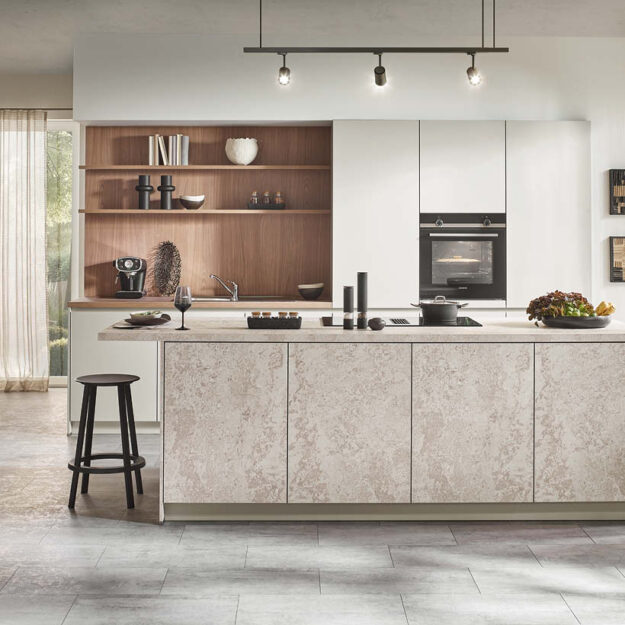 Moderne Häcker Küche mit Kochinsel im Küchenstudio Kandy Bücker – Designküche mit Natursteinoptik und Holzrückwand