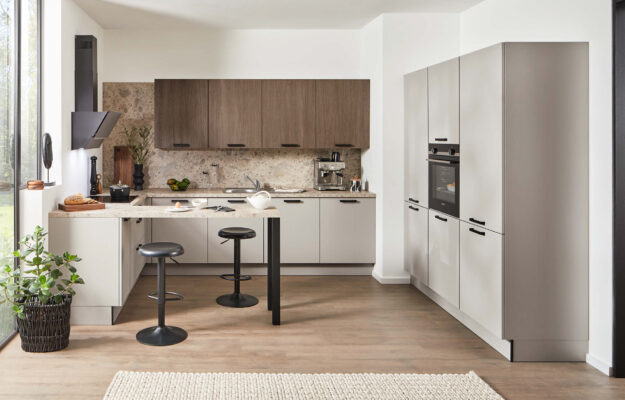 Moderne Häcker L-Küche mit Holzfronten und Frühstückstheke im Küchenstudio Kandy Bücker